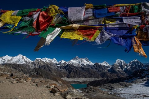 View with Buddhist prayer flags from Renjo La Pass 5417m to the east to Himalaya with Pumori