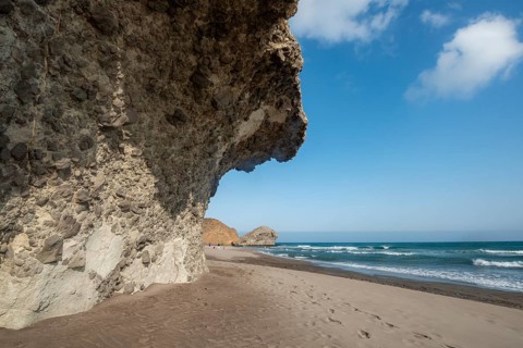 Petrified lava tongues and rocky coast at the beach Playa del Monsul