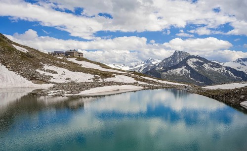 Friesenbergsee with Friesenberghaus in front of snowy mountains
