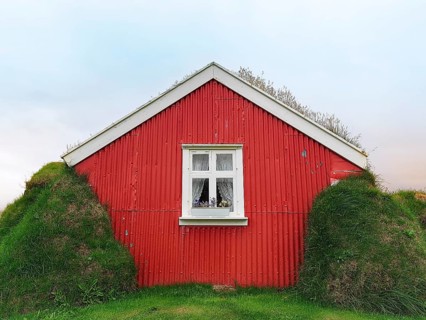 Traditional peat house Lindarbakki with red gable wall