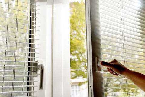 Person opens window in office and wants to air