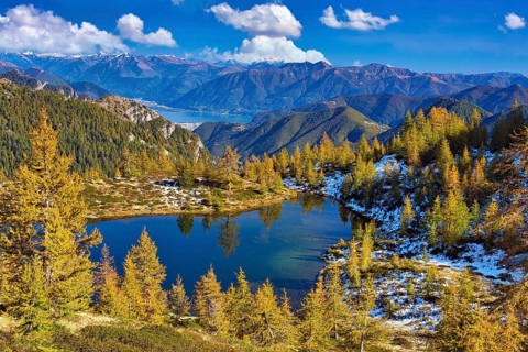 Mountain lake surrounded by autumnal larches