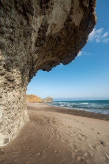 Petrified lava tongues and rocky coast at the beach Playa del Monsul