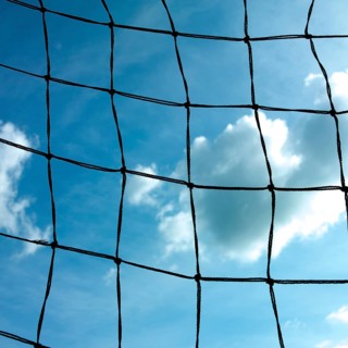 Football goal net against cloudy sky