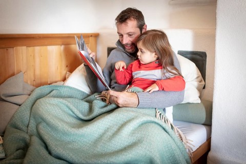 Father reading aloud with daughter