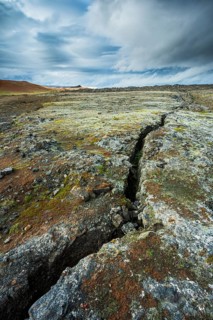 Volcanic fissure Grjotagja with coloured moss in the Krafla