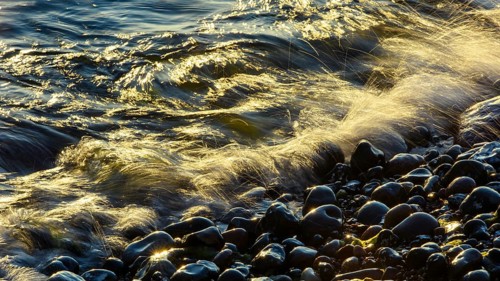 Waves and spray on the beach at sunrise