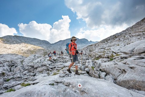 Four hikers in a landscape of washed-out karst rocks