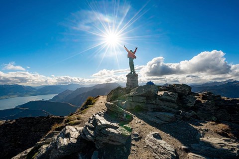 Hiker stretches out his arms in the air