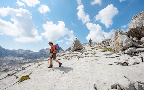 Two hikers in a landscape of washed out karst rocks