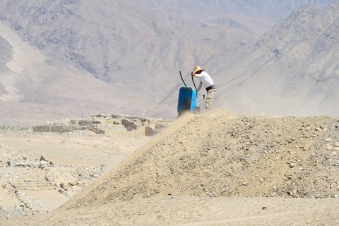 Worker with wheelbarrow in the ruins of Caral