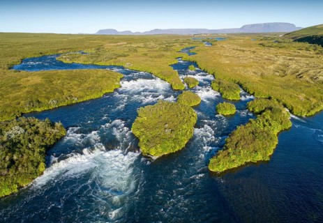 Aerial view of small green grass-covered islands in the river Laxa i Aoaldal
