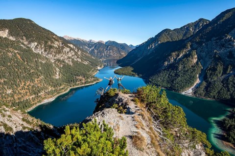 Two hikers stretch arms in the air