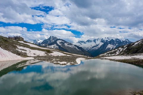 Friesenbergsee with Friesenberghaus in front of snow-covered mountains
