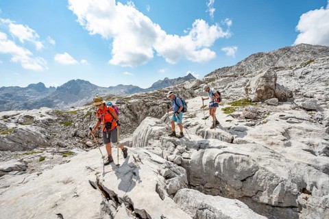 Three hikers in a landscape of washed-out karst rocks