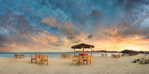 Sandy beach beach with bar at the coral reef Abu-Dabbab at sunset