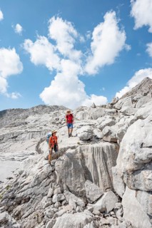 Two hikers in a landscape of washed out karst rocks