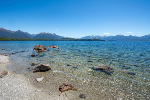 Young man jumps from stone into water
