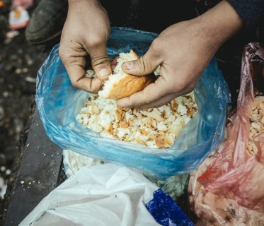 Refugee plucks bread for a meal in a shelter for refugees