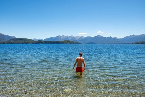 Young man bathes in the lake