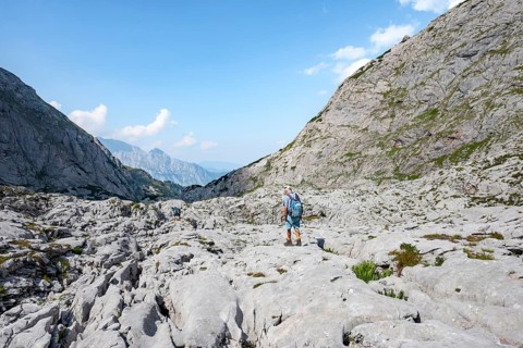 Hikers in a landscape of washed out karst rocks