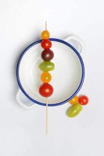 Various cherry tomatoes on wooden skewers on a bowl