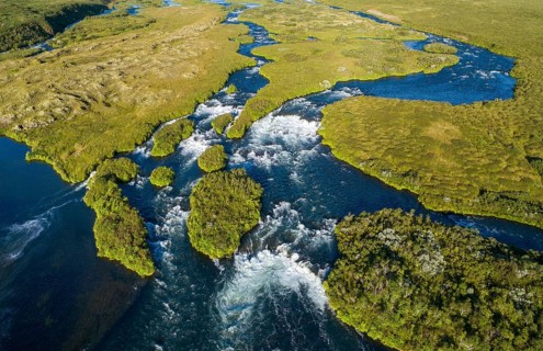 Aerial view of small green grass-covered islands in the river Laxa i Aoaldal