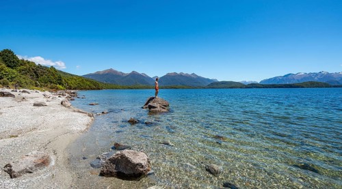 Young man standing on stone in water