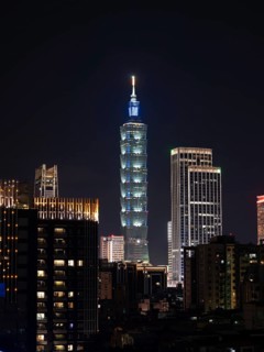 Illuminated Taipei 101 Tower with skyscrapers at night