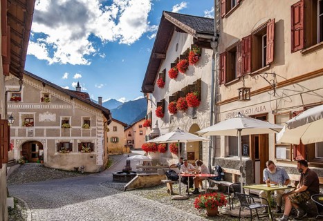 Village street with restaurant terrace and typical houses