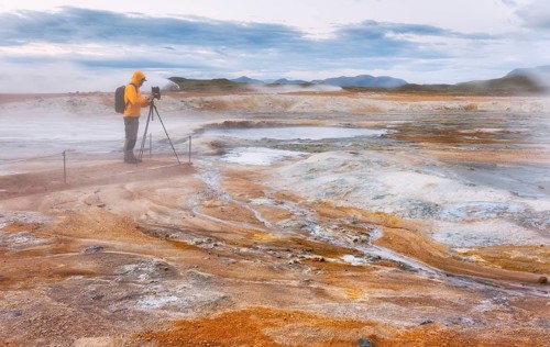 Man in yellow jacket with photo tripod