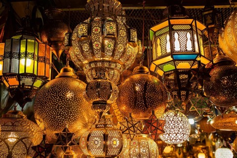 Various lamps made of brass or copper and colored glass for sale hung up