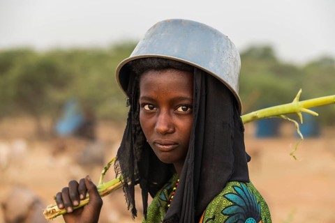 Young girl with a a water pot on her head