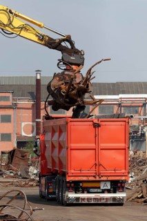 Excavator loads metal scrap onto truck