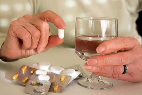 Woman holding medication pill