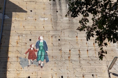 Woman with child fleeing from a bomb alarm