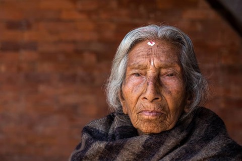 Portrait of an old Hindu woman wrapped in a blanket