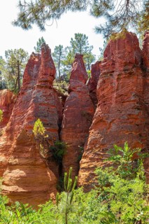 Red pyramid-shaped rocks in the natural park of ochre rocks in Roussillon