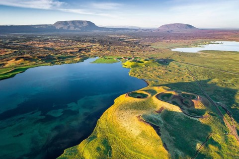 Aerial view of coast with green pseudo-craters