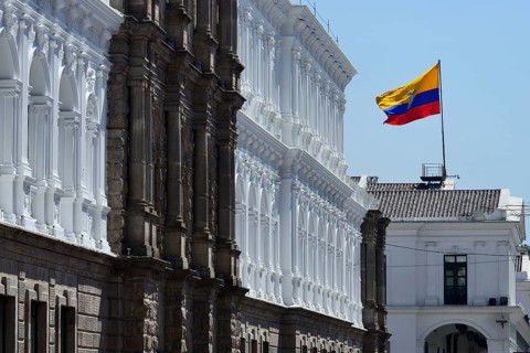 Waving national flag over the seat of government Palacio de Carondelet