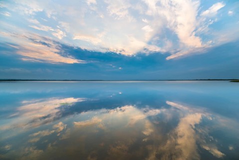 Clouds reflected at sunrise on the smooth lake
