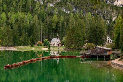 Chapel and boathouse with rowing boats at the Lake Prags Lake