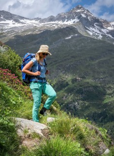 Hiker on hiking trail in front of mountains