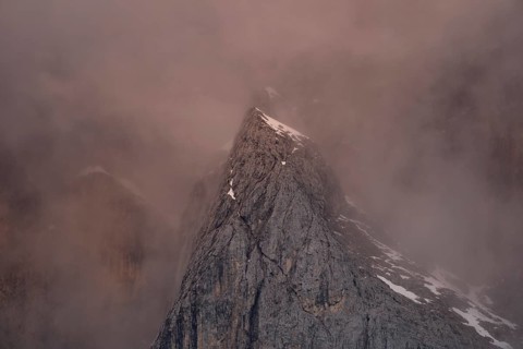 Rock face framed by clouds at sunset