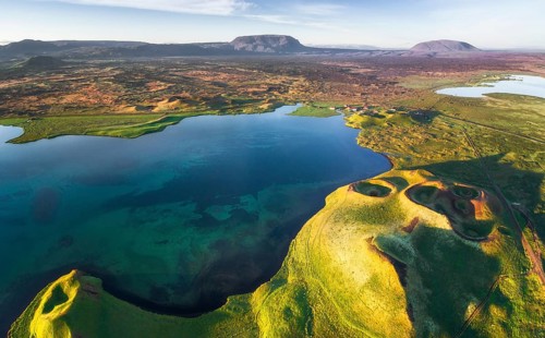 Aerial view of coast with green pseudo-craters