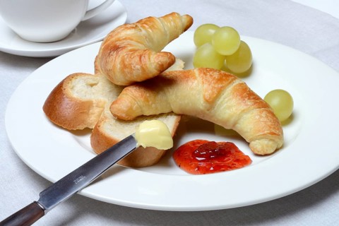 Croissants and slice of butter plait on plate