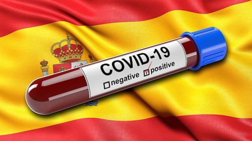 Flag of Spain waving in the wind with a positive Covid-19 blood test tube. 3D illustration