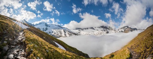 Hiking trail in front of snow-covered mountain peaks