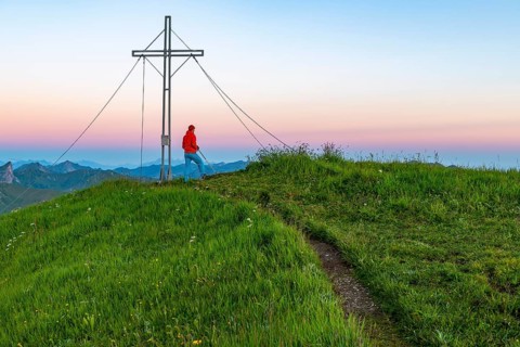 Small mountain trail with mountaineer and summit of the Uentschenspitze at sunrise