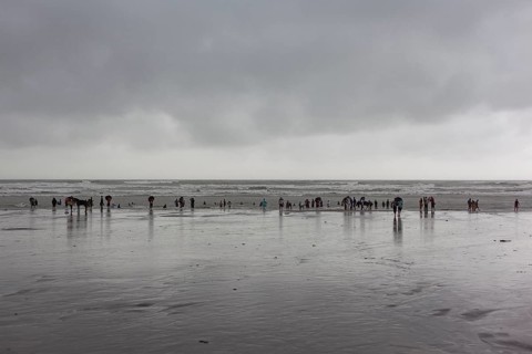 Bathers on the beach from Cox's Bazaar to monsoon rain